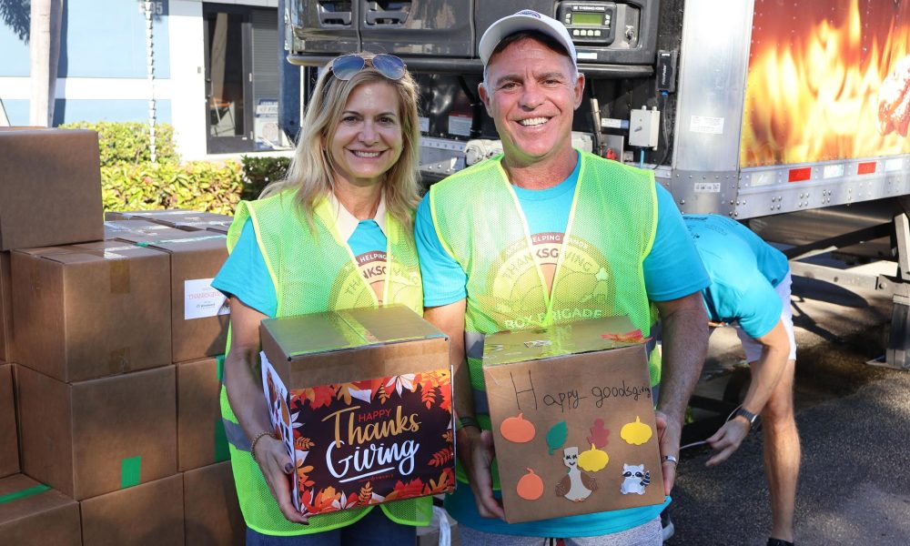 Boca Helping Hands volunteers hold turkeys to be given out in 2025
